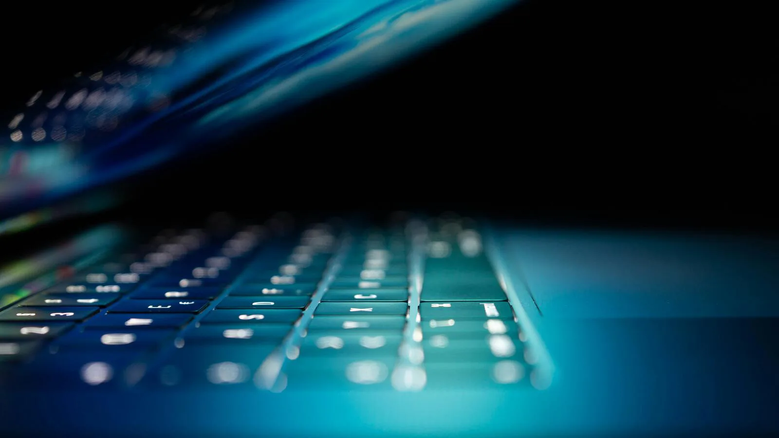 Toetsenbord van een laptop in blauw licht