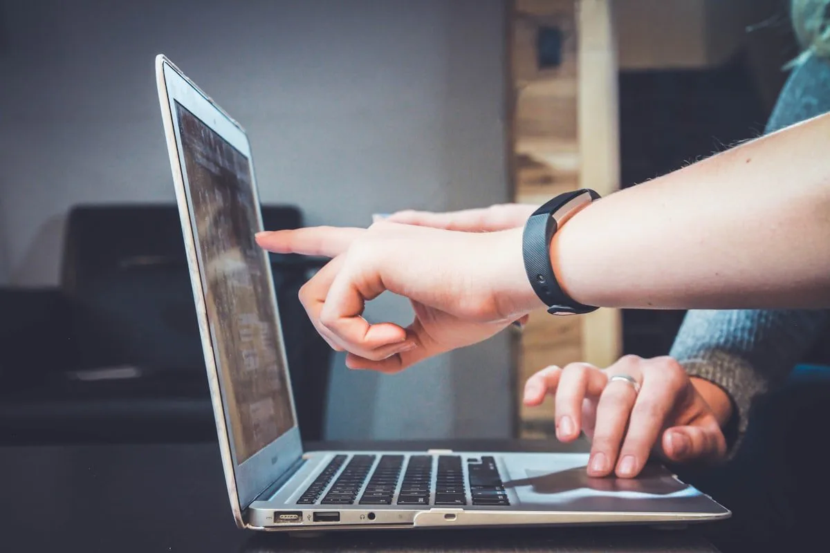 Twee mensen wijzen naar een laptopscherm